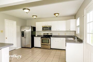 Camby house for rent - A kitchen with white cabinets and a stainless steel refrigerator.