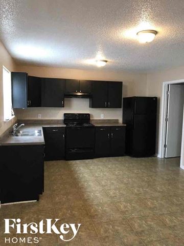 Camby house for rent - a kitchen with black cabinets and a sink and a refrigerator