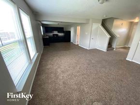Camby house for rent - an empty living room with a carpeted floor and a large window
