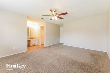 Rowlett house for rent - a spacious living room with carpet and a ceiling fan