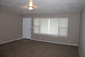 Kansas City house for rent - A room with a carpeted floor and a door.