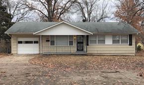 Kansas City house for rent - A small house with a grey roof and a black door.
