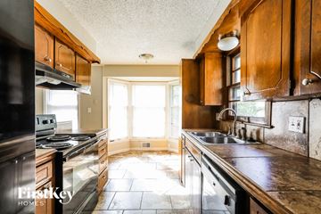 Kansas City house for rent - A kitchen with wooden cabinets and a stove top oven.