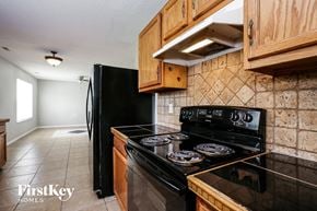 Indianapolis house for rent - a kitchen with black appliances and wood cabinets