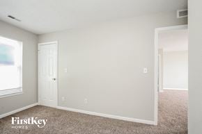 Indianapolis house for rent - a bedroom with white walls and carpet and a door to a closet