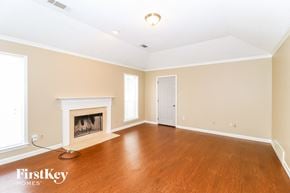 Cordova house for rent - A spacious room with a fireplace and wooden floors.