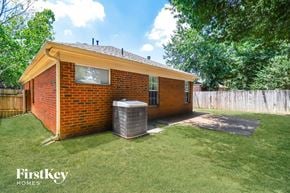 Cordova house for rent - A brick house with a window and a door is shown with a grassy area in front.