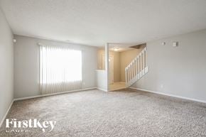 Indianapolis house for rent - A spacious room with a staircase leading to another room.