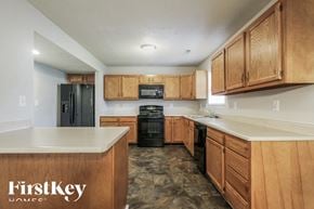 Indianapolis house for rent - A kitchen with wooden cabinets and a FirstKey Homes logo.