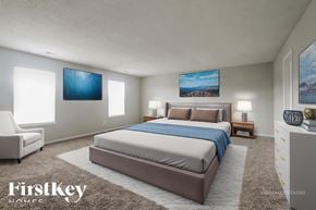 Indianapolis house for rent - A bedroom with a large bed and two paintings on the wall.
