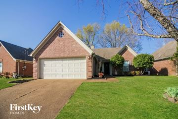Cordova house for rent - a house with a white garage door in front of a lawn