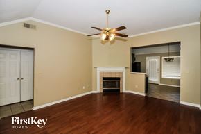 Cordova house for rent - an empty living room with a ceiling fan and a fireplace