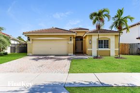 Cutler Bay house for rent - a yellow house with palm trees and a driveway