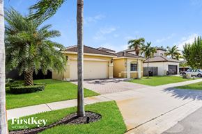 Cutler Bay house for rent - a yellow house with palm trees and a driveway