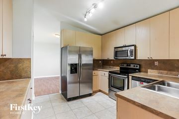 Cutler Bay house for rent - a kitchen with stainless steel appliances and white cabinets