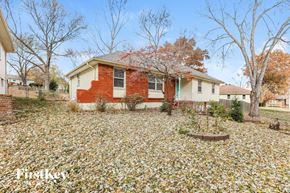 Kansas City house for rent - a red brick house with a yard covered in fallen leaves