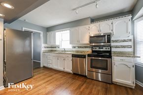 Kansas City house for rent - a kitchen with white cabinets and stainless steel appliances