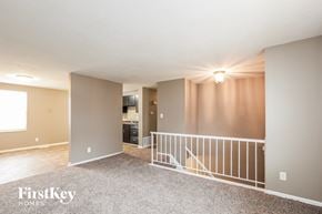Indianapolis house for rent - A spacious room with a balcony and a kitchen area.