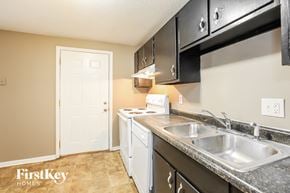 Indianapolis house for rent - A kitchen with a white door and a sink.