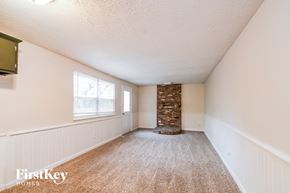 Indianapolis house for rent - A room with a carpeted floor and a stone pillar in the middle.