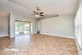Fort Myers house for rent - a spacious living room with tile flooring and a ceiling fan
