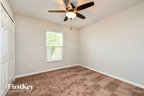 Fort Myers house for rent - a bedroom with carpet and a ceiling fan