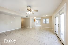 Glendale house for rent - an empty living room with a ceiling fan and tiled floors