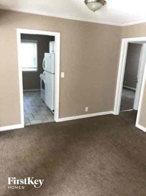 Kansas City house for rent - an empty living room with a white refrigerator in it