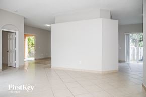 Cutler Bay house for rent - A large empty room with a white tile floor and a white wall.