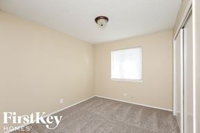 Fort Worth house for rent - a bedroom with a carpeted floor and a window