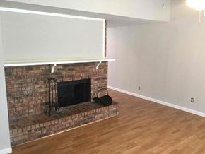 Rowlett house for rent - a living room with a brick fireplace and a wooden floor