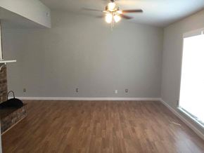 Rowlett house for rent - an empty living room with wood floors and a ceiling fan