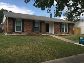 Rowlett house for rent - a small brick house with a lawn and a sidewalk