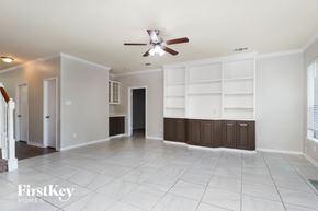 Spring house for rent - A spacious room with a ceiling fan and built-in shelves.