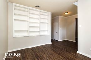 Spring house for rent - A room with a white shelving unit and wooden floors.