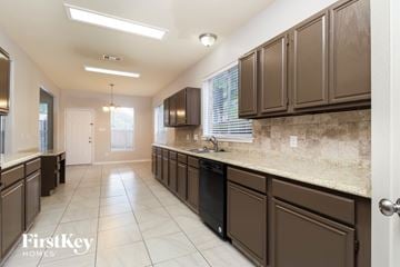 Spring house for rent - A kitchen with brown cabinets and a black dishwasher.