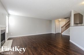 Indianapolis house for rent - A spacious room with wooden flooring and a staircase in the background.