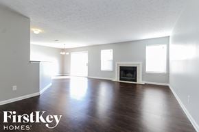 Indianapolis house for rent - A spacious room with a fireplace and wooden floors.
