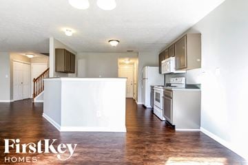 Indianapolis house for rent - A kitchen with a white fridge and stove top oven.