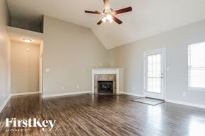 Olive Branch house for rent - a empty living room with a ceiling fan and a fireplace