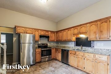 Olive Branch house for rent - a kitchen with wooden cabinets and stainless steel appliances