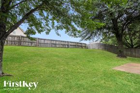 Olive Branch house for rent - a backyard with a fence and grass and trees