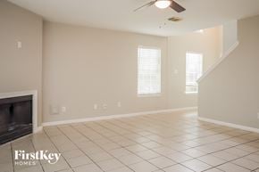 Houston house for rent - an empty living room with a fireplace and tiled floor