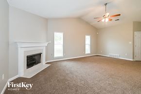 Southaven house for rent - an empty living room with a fireplace and a ceiling fan