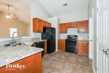 Southaven house for rent - a kitchen with black appliances and marble counter tops