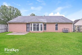 Southaven house for rent - a brick house with a grassy yard and a fence