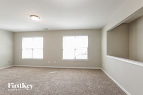 Charlotte house for rent - A sparsely furnished room with a carpeted floor and two windows.