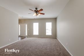 Charlotte house for rent - A spacious room with a ceiling fan and carpeted floor.