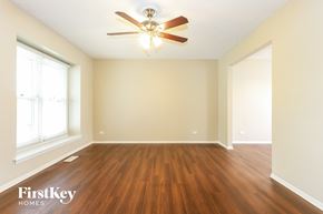 Orland Hills house for rent - A room with a ceiling fan and wooden flooring.