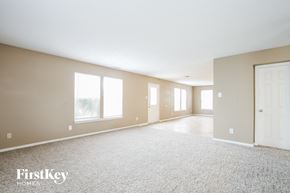 Pendleton house for rent - A spacious room with a carpeted floor and a door on the right side.